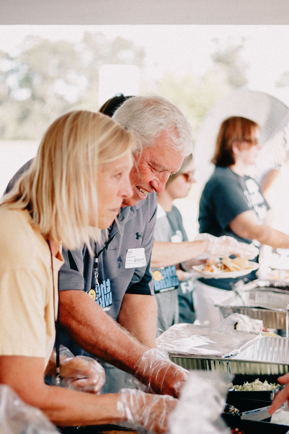 Volunteers in gloves serving a community meal